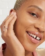 Model smiling and resting their chin in their hand