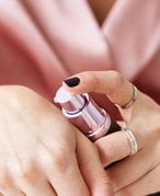 Close-up picture of someone applying makeup primer to the back of their hand