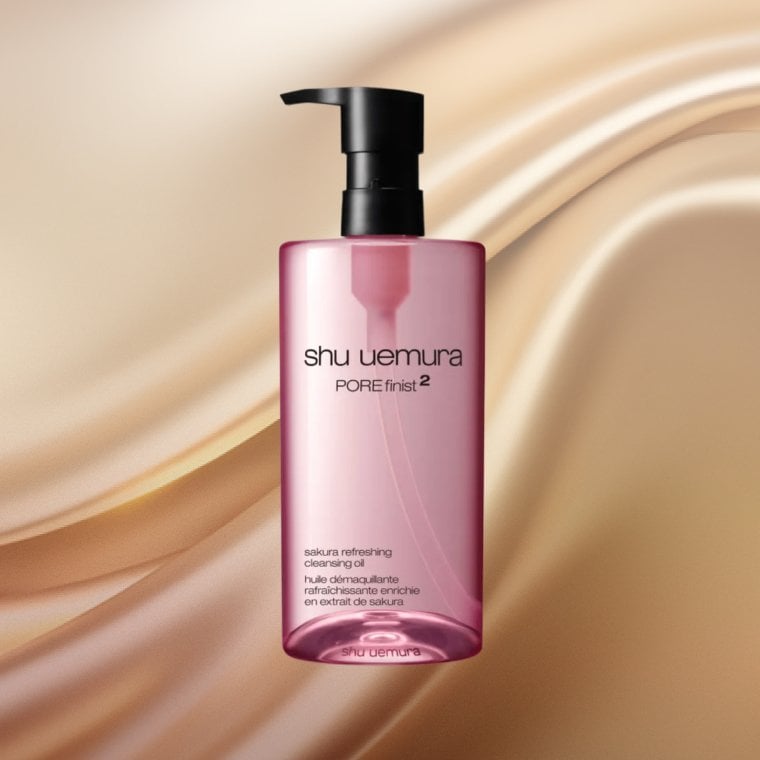 Bottle of Shu Uemura Porefinist2 Sakura Refreshing Cleansing Oil on a textured background