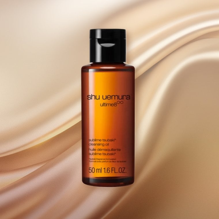 Bottle of Shu Uemura Ultimate8 Sublime Beauty Cleansing Oil on a textured background
